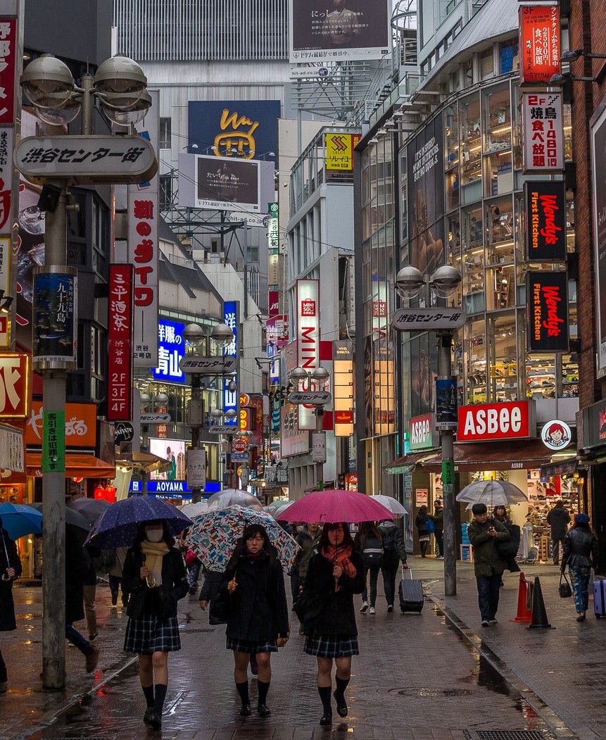 People walking on street with neon signs, Tokyo, Japan